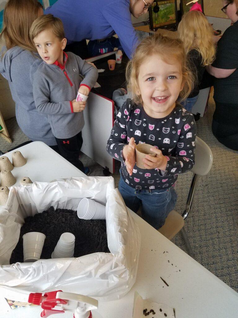 A few happy kids with pots and lots of dirt.