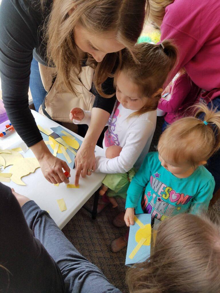 A parent helping glue on sun rays.