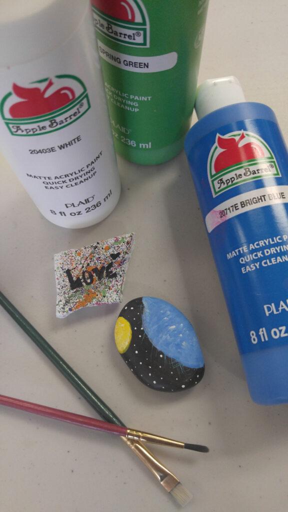 Painted rocks, acrylic paint, and paintbrushes.