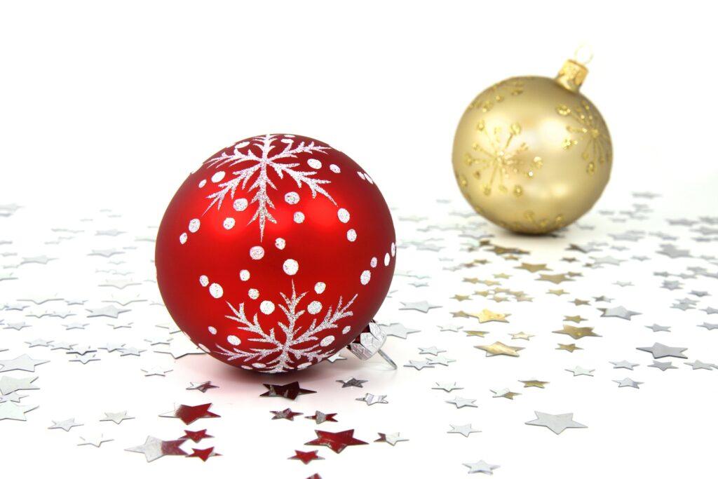 Gold and red Christmas ornaments with silver star glitter underneath.
