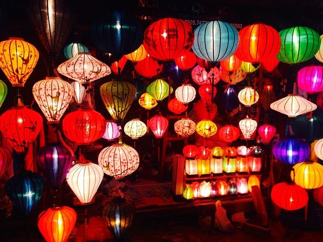Colorful lanterns glow brightly in a market display, creating a warm, festive ambiance.