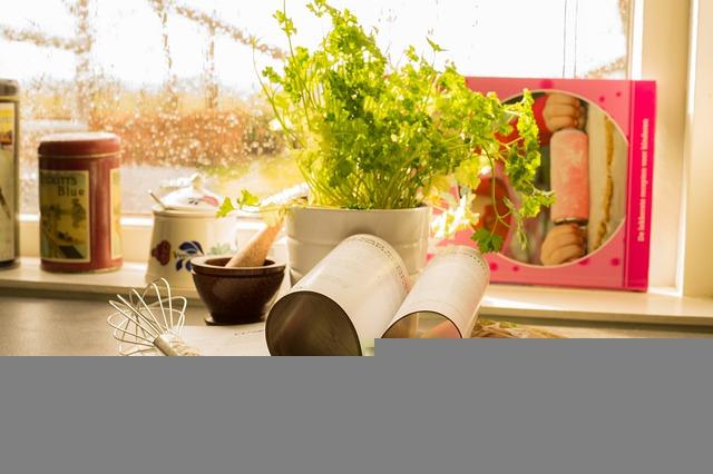 Kitchen counter with herbs, rolling pin, whisk, and cookbook.