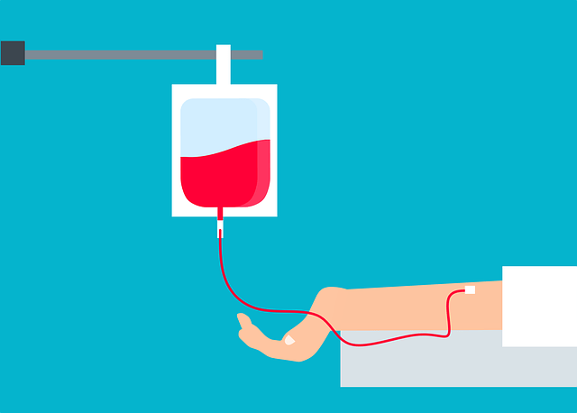 Arm receiving blood via IV drip with a red bag.